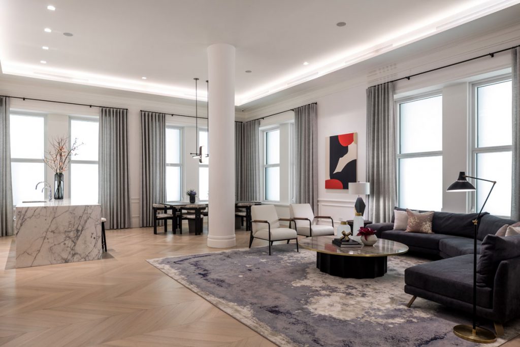 Open plan living interior design with large feature rug, light wood floor and marble kitchen island