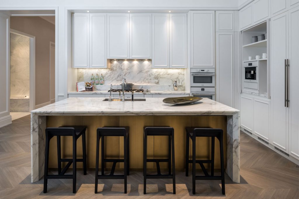 Modern white kitchen design with marble island and black bar stools