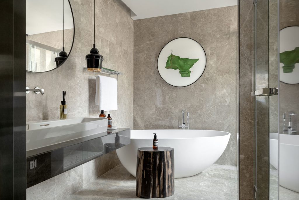 Concrete surfaces in modern bathroom design with oval bath tub