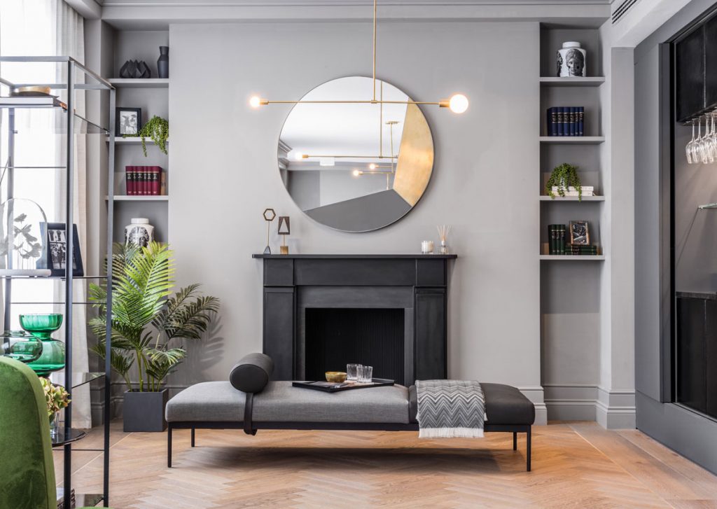 Interior decor featuring black fireplace with contemporary circle mirror