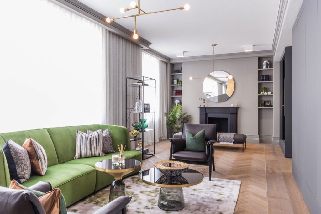 Living room interior with statement green sofa and parquet wood flooring