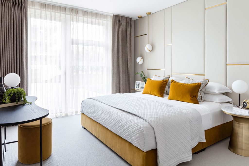 Bedroom interior styling with panel wall feature and velvet yellow details